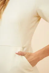Vestido marrón de lana fina, corte a la rodilla, con cuello redondo, mangas cortas y bolsillos laterales.