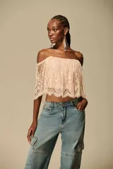 Top color rosa pálido de encaje floral, con escote off-shoulder y corte cropped.