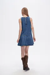 Vestido corto de denim azul, sin mangas, con cuello redondo y falda con volados.