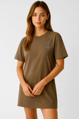 Vestido manga corta color marrón, de corte holgado y cuello a la base. Presenta un estampado en el pecho.