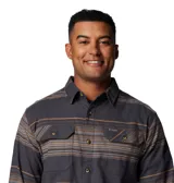 Camisa de franela a cuadros con estiramiento confort, color gris con rayas horizontales marrones y beige. Cuenta con cuello abotonado, cierre frontal con botones, dos bolsillos en el pecho con cierre de botón y puños abotonados.