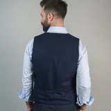 Chaleco de vestir marrón claro con textura de espiga, cuello en V, cierre frontal con botones y bolsillos ribeteados.
