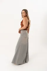 Jean súper campana de tiro alto, color celeste vintage, con pierna extra ancha y caída fluida. Cuenta con bolsillos delanteros y traseros, y cierre frontal con cremallera y botón metálico.