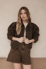 Bermuda de jean color marrón con efecto desgastado, tiro medio y corte holgado.