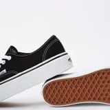 Zapatillas negras de lona con suela alta y cordones, diseño clásico de Vans.