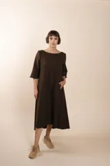 Vestido largo debajo de la rodilla, acampanado, color marrón, con cuello bote, bolsillos en el corte y mangas 3/4.