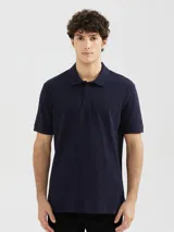 Polo azul marino de piqué de algodón, de manga corta y corte clásico. Cierre frontal con dos botones.