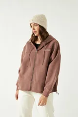 Campera marrón de felpa con cierre, capucha ajustable y bolsillos frontales tipo canguro.