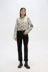 Chaqueta corta de algodón con estampado animal print en tonos grisáceos, cuello redondo, cierre frontal con botones a presión, bolsillos de parche en el pecho y corte recto.