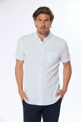Camisa celeste y blanca a rayas verticales, de lino y algodón, manga corta, corte slim fit, con cuello abotonado y bolsillo en el pecho.