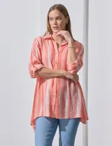 Camisa larga a rayas verticales color salmón y blanco, de rayón y poliéster, con cuello con solapa, abertura central con botones, mangas largas regulables con presilla y botón, y tajos laterales.