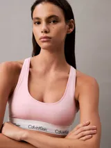 Conjunto Calvin Klein color rosa pálido, compuesto por un corpiño deportivo sin relleno y una tanga, ambos con banda elástica blanca con el logo de la marca.