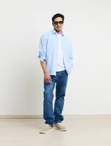 Camisa celeste de manga larga con cuello button-down, confeccionada en tejido rústico de algodón y lino.