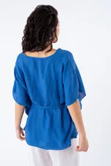 Blusa azul de viscosa con escote en V y mangas cortas tipo kimono. Incluye lazo del mismo material para ajustar en la cintura.
