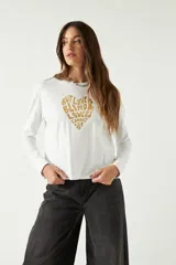 Remera blanca de manga larga con cuello bote y estampado frontal con la frase "But love is blind & lovers cannot see" en forma de corazón.
