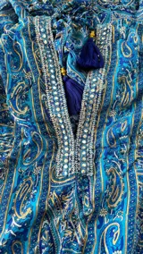 Vestido largo maxi de tirantes halter, escote en V profundo y cintura fruncida. Presenta un estampado paisley en tonos azules y turquesas.