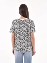 Remera blanca con estampado de ojos y pestañas en negro.