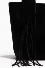 Bolso shopper negro de tejido cepillado con doble asa y flecos largos. Cuenta con cierre magnético oculto en la parte superior, compartimento interior con cierre y forro de tafeta.