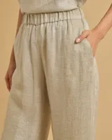 Pantalón de pierna ancha, tiro medio con cintura alta elástica y bolsillos laterales, color dorado brillante.