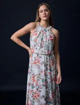 Vestido largo de gasa estampada con flores de colores, escote halter plisado, corte en la cintura elastizado, abertura en la espalda con lazo de ajuste y forro interno a tono.