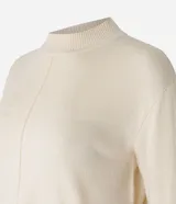 Blusa de punto color crema, con cuello alto y mangas largas.