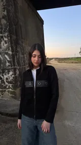 Campera negra de lana con frente de cuero, cierre frontal con cremallera y mangas largas.