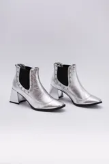 Botas cortas negras de cuero con elásticos laterales, taco cuadrado y apliques de tachas plateadas.