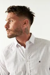 Camisa celeste a cuadros, de corte slim fit, manga larga y logo bordado. Confeccionada en 100% algodón.