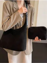 Bolso en tono marrón, con diseño minimalista y asa amplia para llevar al hombro.