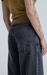Pantalón de denim negro con calce wide leg y cinco bolsillos.