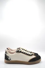 Zapatillas urbanas de cuero color beige con puntera y cordones marrones. Presentan un panel de animal print en el talón y suela de goma color caramelo.