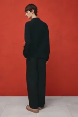Camisa negra de tejido suave con cuello abierto, tapeta lisa y canesú en la espalda. Modelo de manga larga con cierre ajustable de botones en los puños y tapeta con botón. Bajo recto y corte estándar.