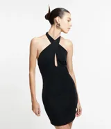 Vestido corto negro con cuello halter cruzado, lazo en el cuello y detalle cutout en el abdomen. Sin mangas y espalda descubierta. Ajustado al cuerpo.