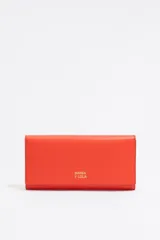 Billetera larga color naranja de piel reciclada con logo Bimba y Lola dorado. Tiene cierre de presión, tarjetero y monedero en el interior.