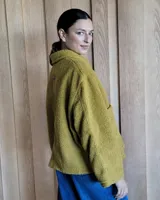 Chaqueta oversize color camel, con cierre frontal y bolsillo frontal, diseñada para mayor calidez.