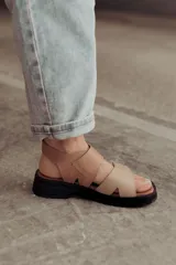 Sandalias color beige con tiras de cuero y ajuste con velcro, con base chunky negra.