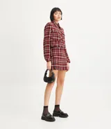 Minifalda de tweed a cuadros en tonos rojo, blanco y negro, con flecos en el ruedo.