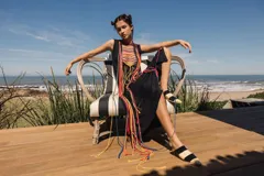 Vestido midi negro de jersey con ojalillos metálicos en el escote e intervención de hilado de algodón de colores.