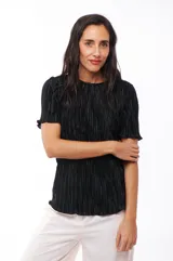 Blusa negra con textura plisada, cuello redondo y mangas cortas con volados.