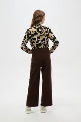 Pantalón de algodón color beige, de tiro alto, corte ancho y largo, con bolsillos frontales tipo parche.