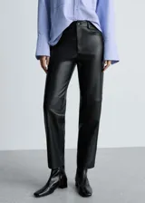 Pantalón largo de tiro alto color negro, con efecto piel, diseño recto, cinco bolsillos, trabillas y cierre de cremallera y botón.