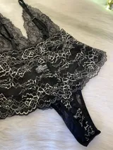 Body entallado de encaje bitono negro con detalles en color hueso, breteles regulables y escote pronunciado. El encaje es suave y elastizado.