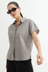Camisa gris sin mangas de lino con cuello clásico y cierre frontal con botones.