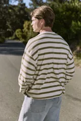 Buzo de manga larga color crudo con rayas horizontales color verde oliva, de corte oversize cropped y cuello redondo.