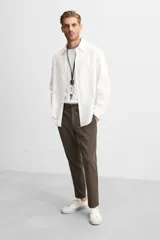 Pantalón slim fit negro confeccionado en tejido con elasticidad en ambas direcciones. Cuenta con bolsillos frontales y traseros de vivo con botón. Cierre frontal con cremallera y botón.