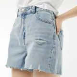 Short de jean celeste con efecto desgastado y terminaciones desflecadas.