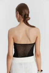 Top strapless con diseño de puntos calados y corsetero, con transparencias en el centro delantero y la espalda.