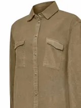 Camisa azul de cotelé de algodón orgánico, con calce holgado, cierre de botones a presión, cuello camisero y mangas largas.