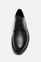 Zapato de vestir tipo derby de cuero negro, con puntera lisa, horma redonda y suela con ligero tacón.