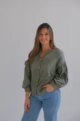 Camisa verde militar con bordado de flores, cuello mao con volados y mangas largas abullonadas con puños elásticos.